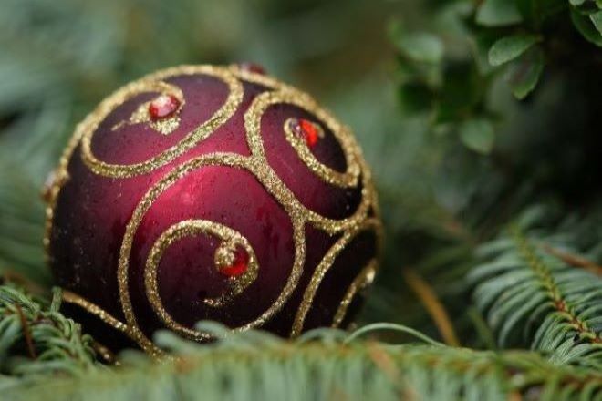 ornament-g6ffc2252a_1280 jul Et rødt julepynt med guldmønster på en grøn grangren.